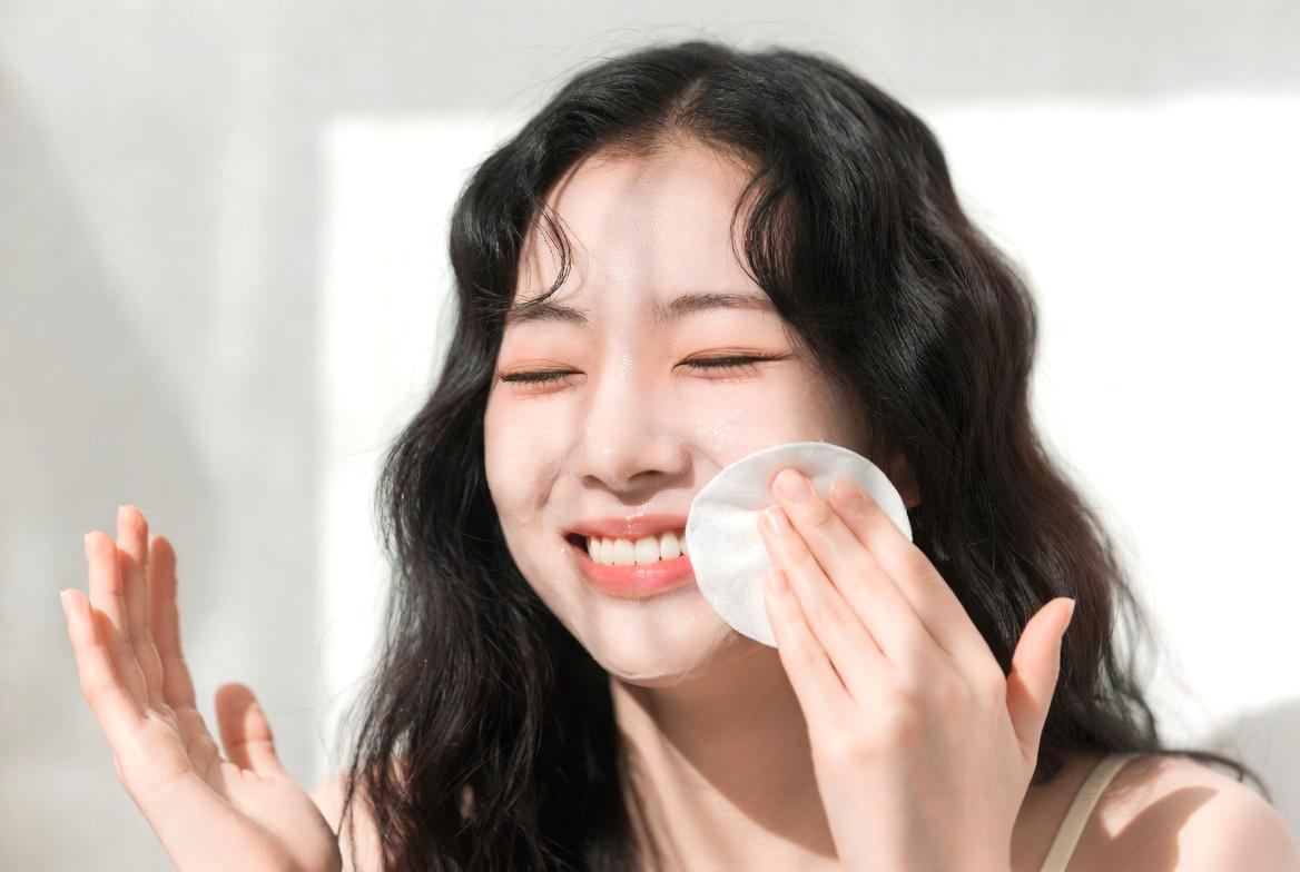 鏡を見ながら目元のシワを気にする女性の様子