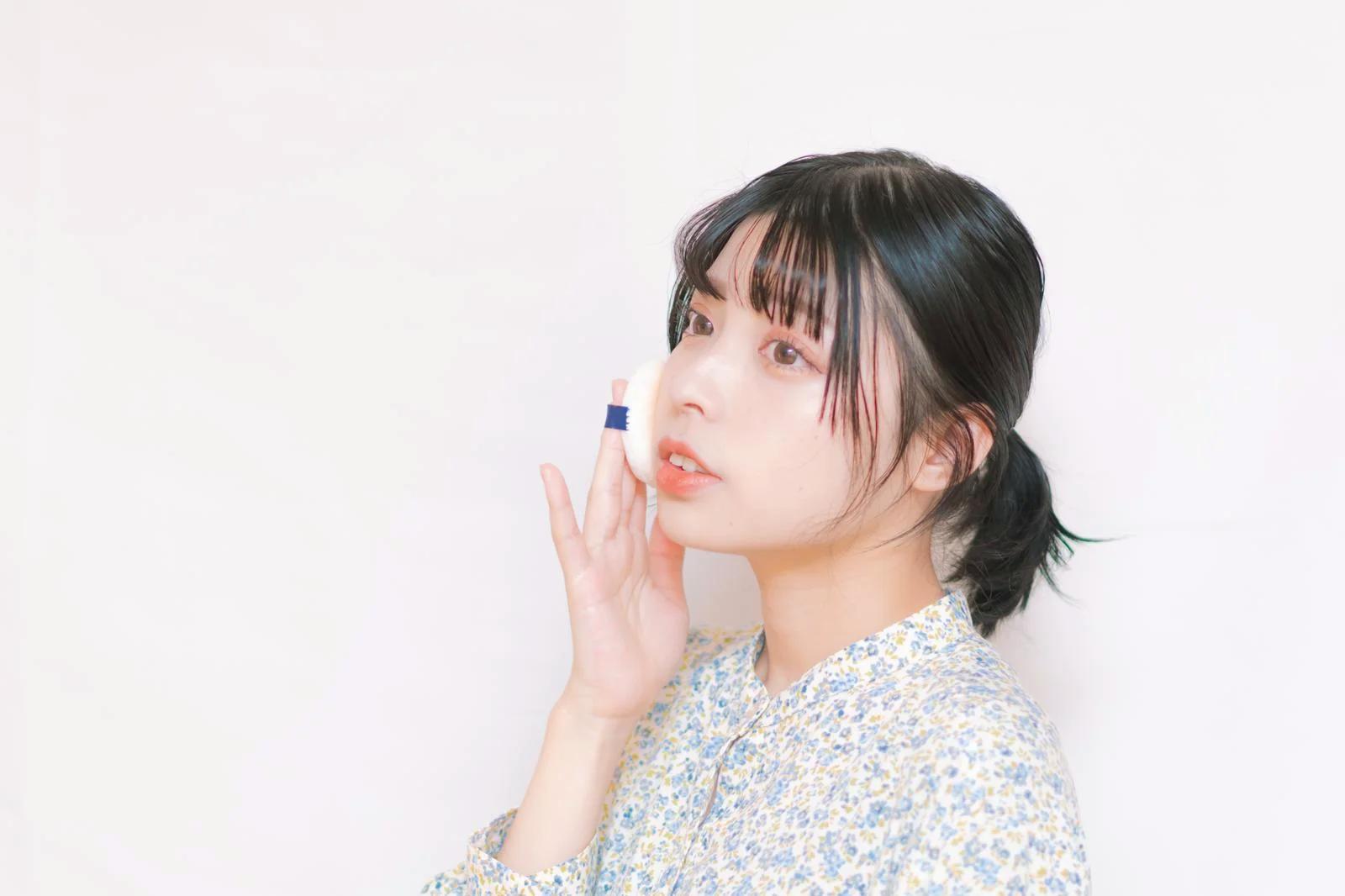 外出先で日焼け止めを塗り直すスマートな女性の手元
