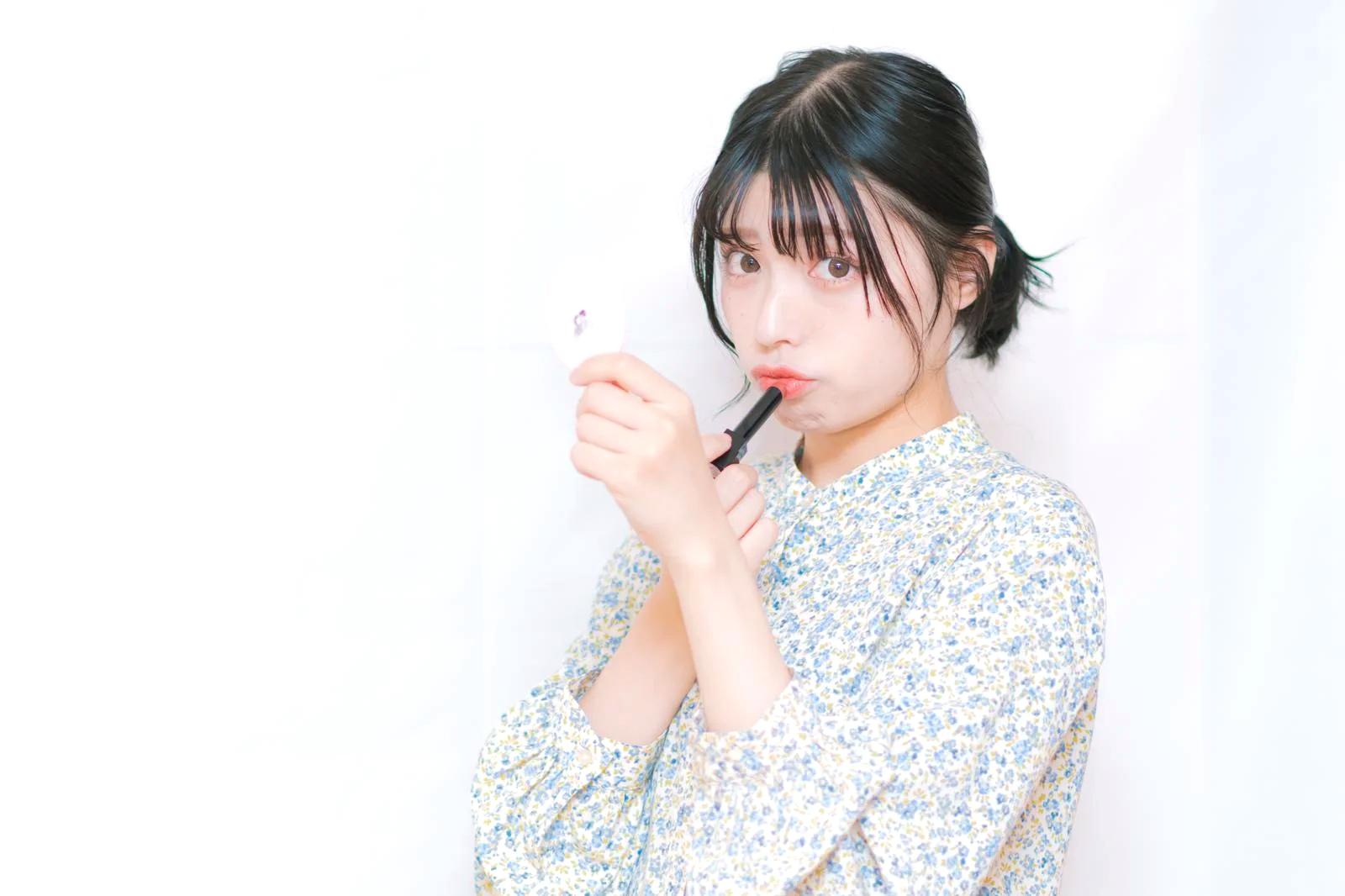 夕方のメイク直しで日焼け止めバームを重ねる女性の手元