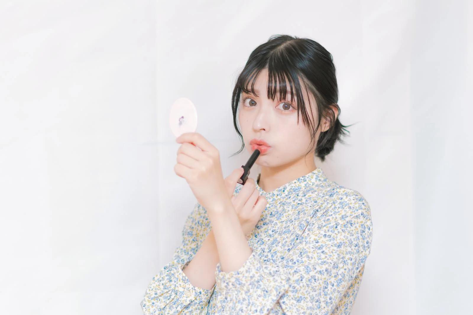 鏡の前で表情筋トレーニングをする女性のイメージ