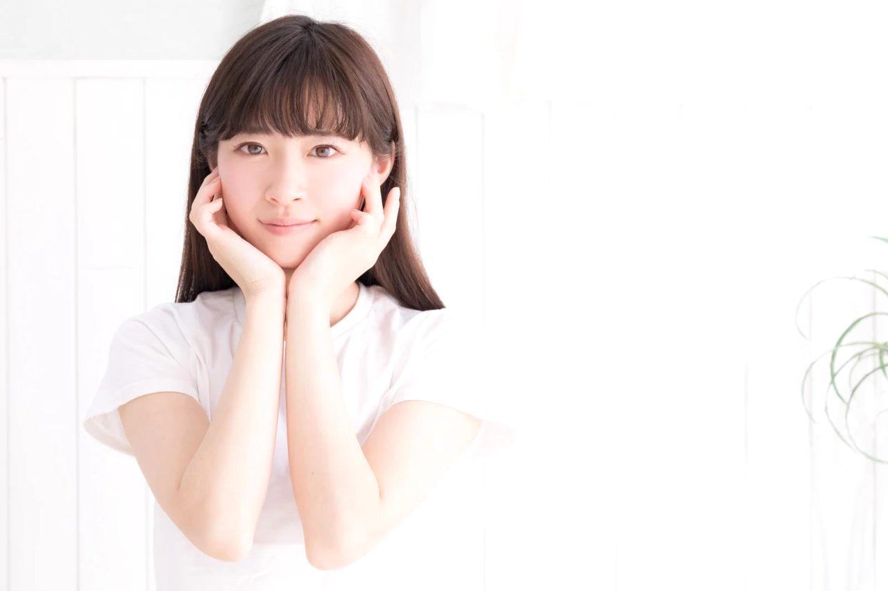 ハンドクリームを手のひらで温めてから指先まで丁寧にマッサージする女性