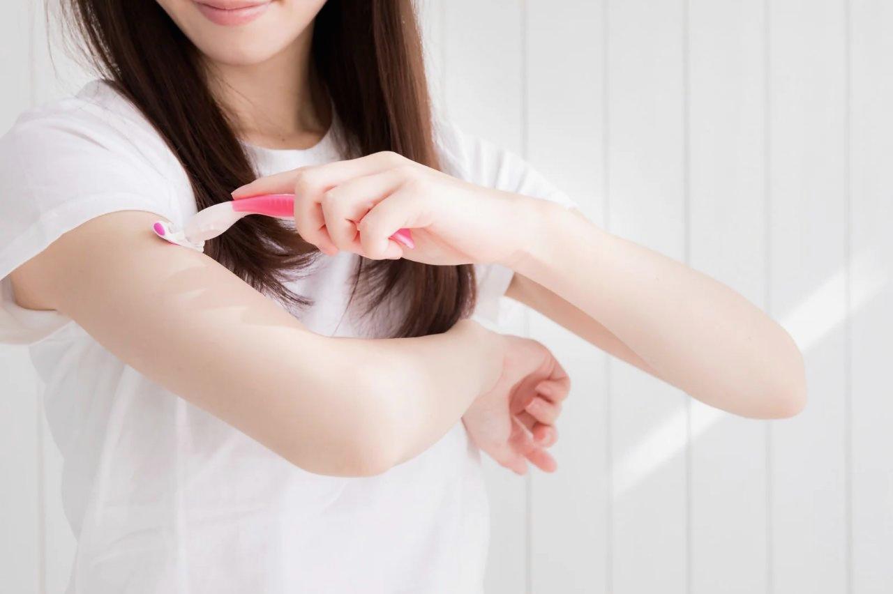 スキンケアアイテムで保湿ケアをする女性の手元