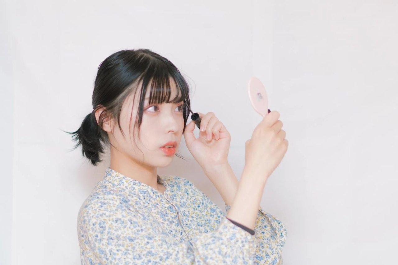 コームで眉をとかしながらハサミで少しずつ整える手元