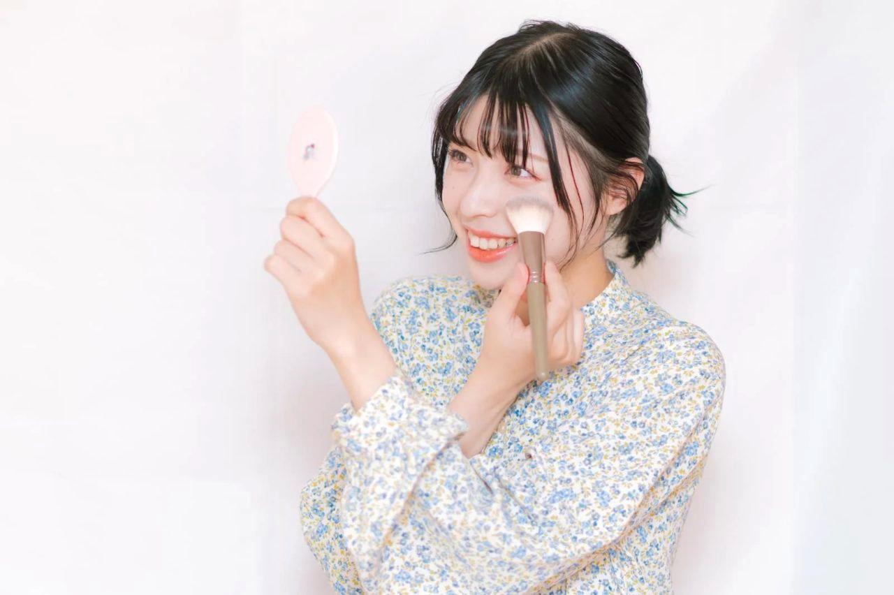 外出先でミスト型UVスプレーを顔に吹きかけている女性と、そっとパウダーを押さえる手元