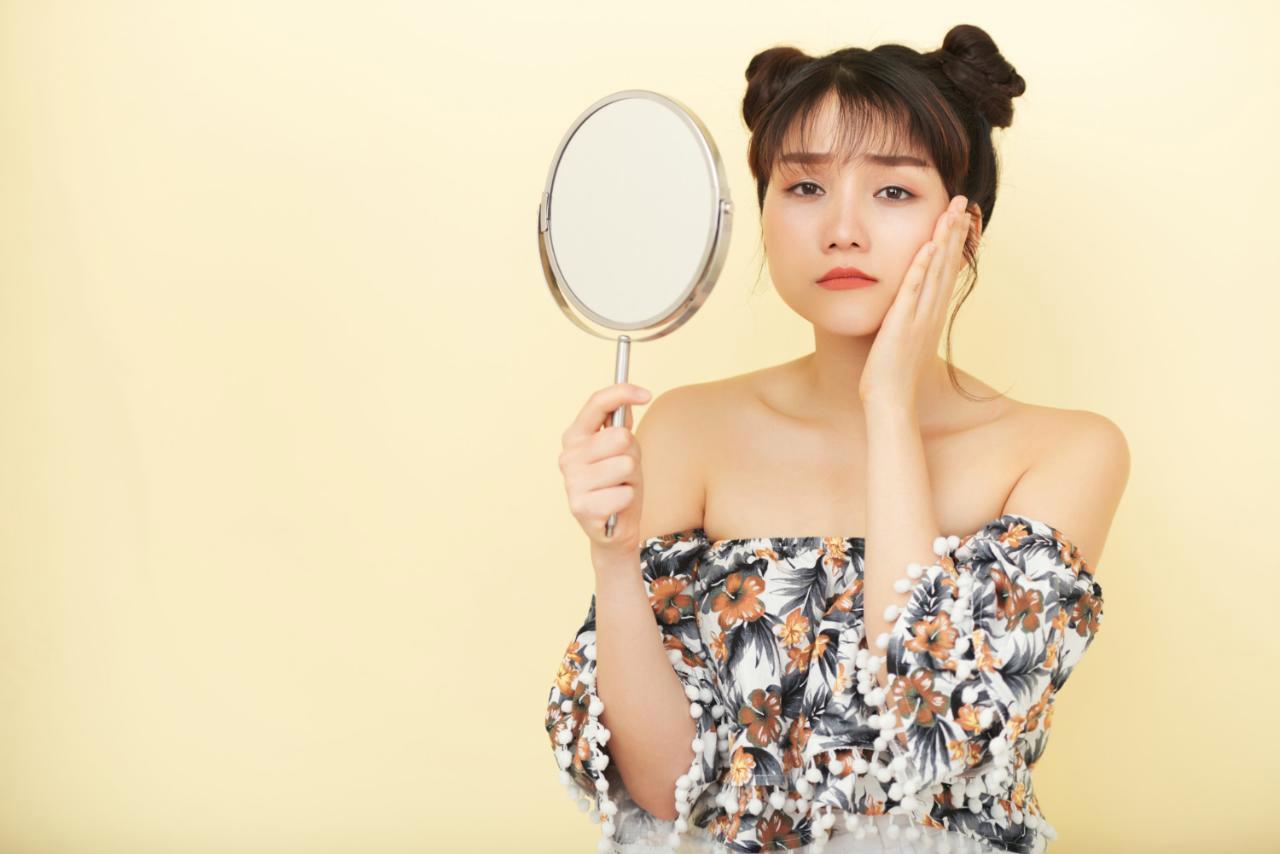 ブラシで髪をとかす女性の手元と、抜け落ちた髪の毛のクローズアップ