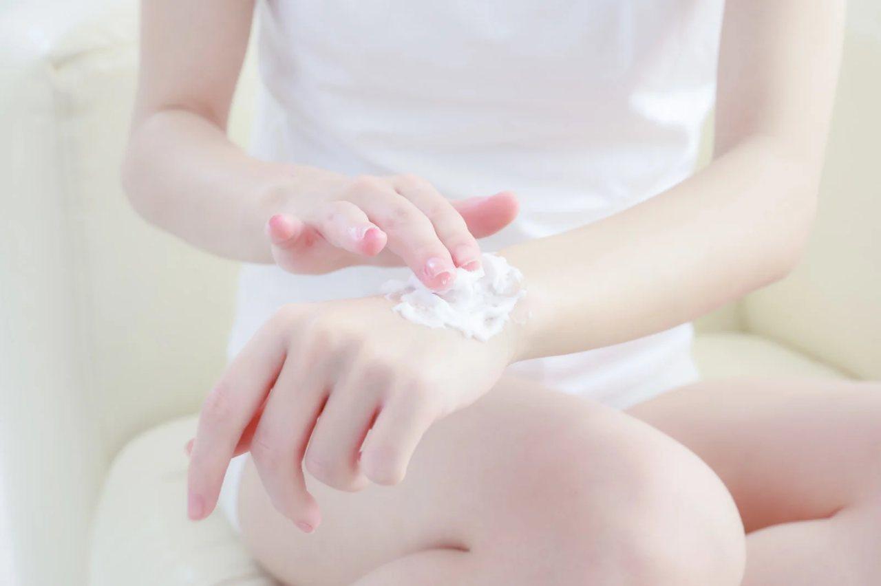 オフィスで夕方になってもしっとり感が続く肌を確認するビジネス女性