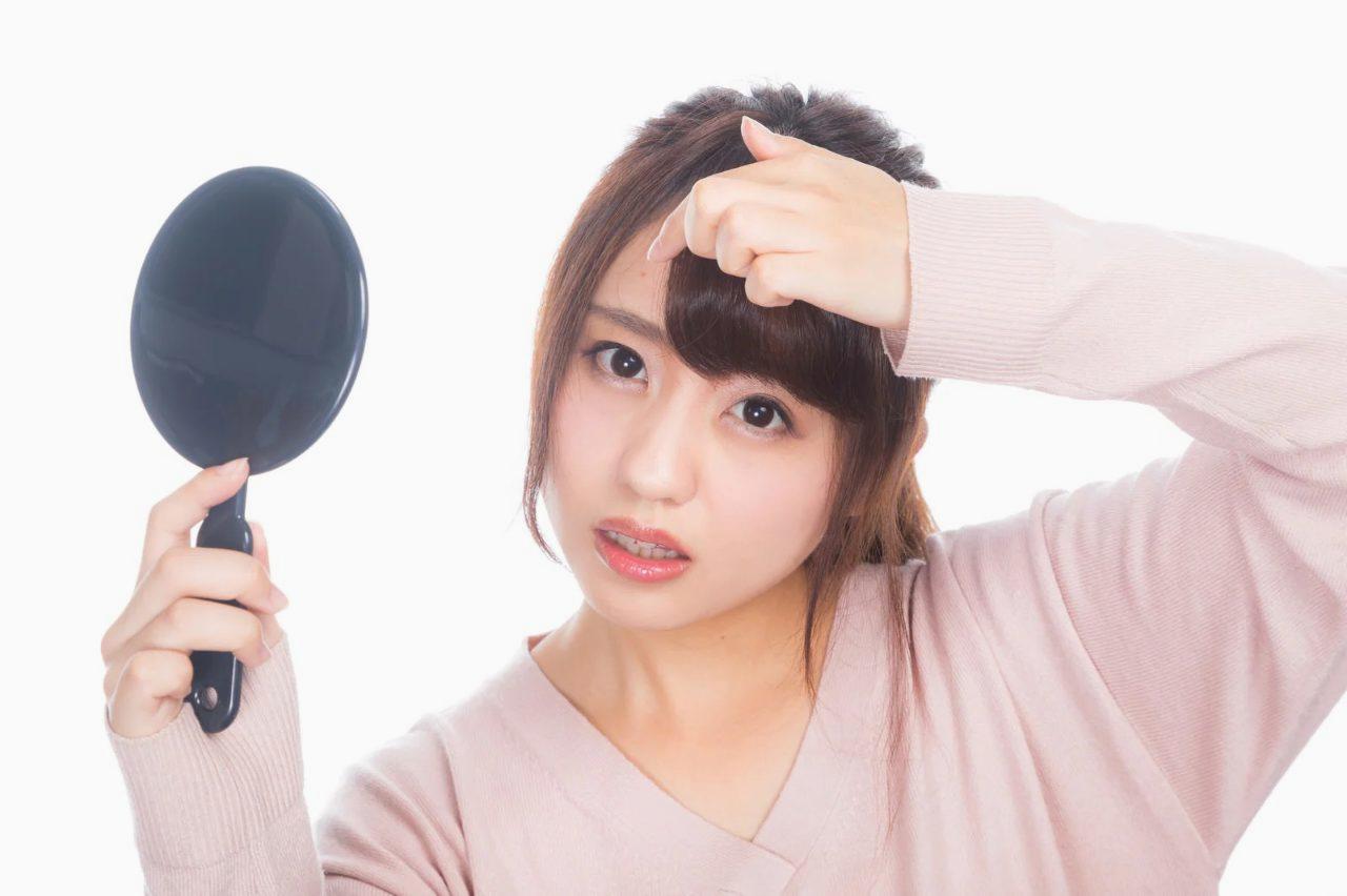 鏡を見つめるアラフィフ女性の真剣な表情