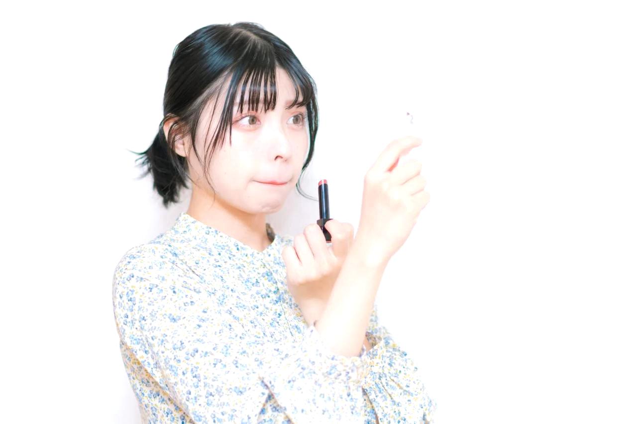 朝の光の中でリップケアを行い、唇の保湿と紫外線対策を整える女性
