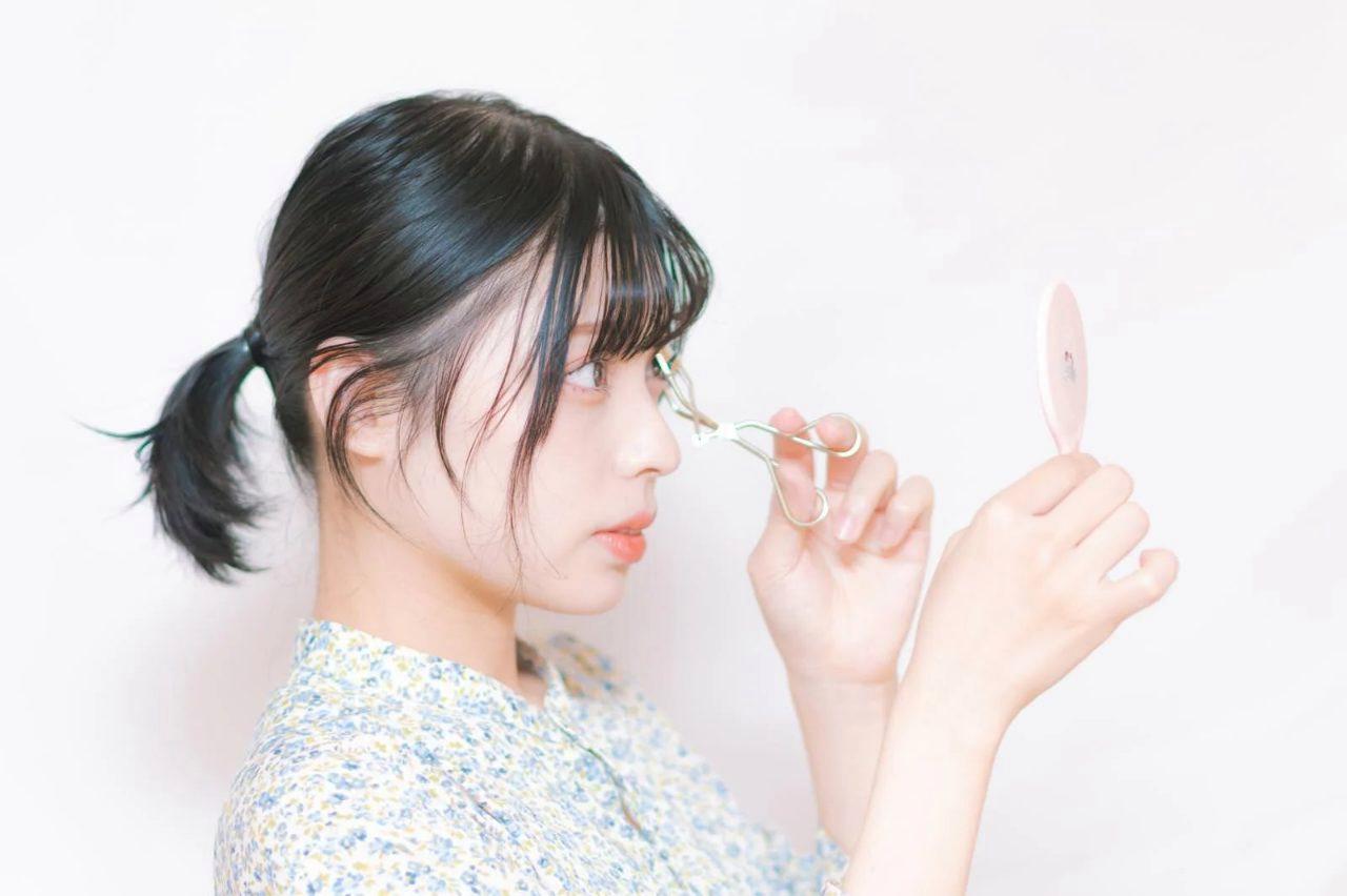 鏡で目元の小ジワを気にする女性