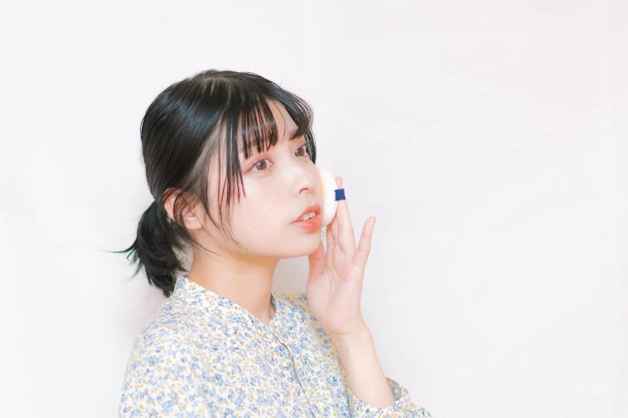 日焼け止めミストを顔にふんわりスプレーしている女性の写真