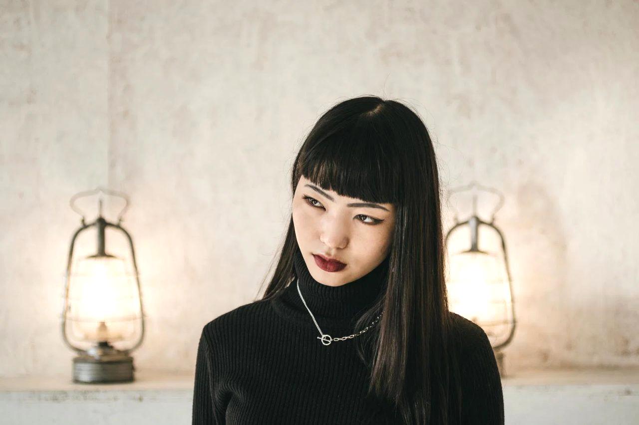 ドライヤーで細い髪の根元を立ち上げて乾かす女性のイメージ