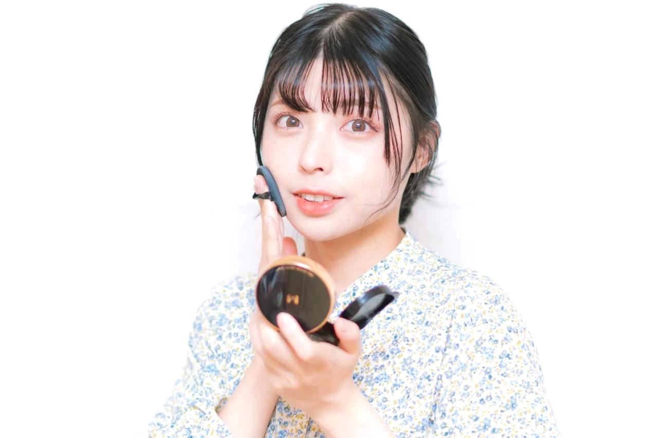 頬骨・鼻筋・あご先にハイライトクリームをポンポンと置くメイク中の女性