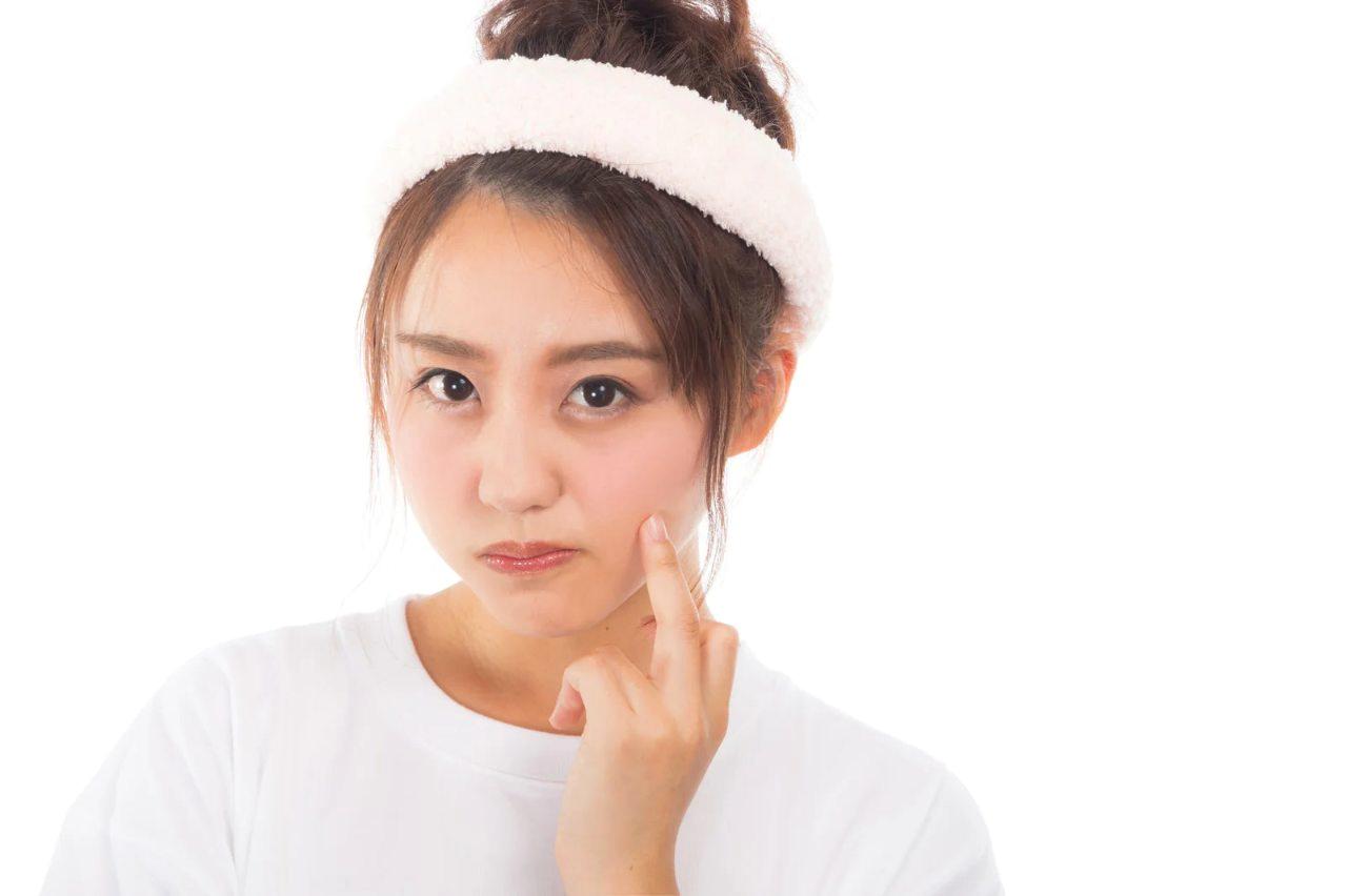 肌荒れを気にして鏡を見る女性のクローズアップ