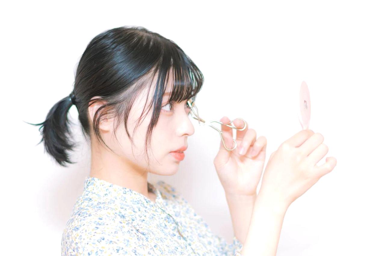 時計のそばでコンパクトなメイクアイテムを手早く使う女性のイラスト