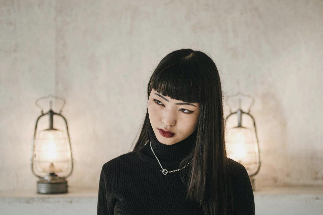 濡れた髪を無理にブラッシングして切れ毛が発生している女性の後ろ姿
