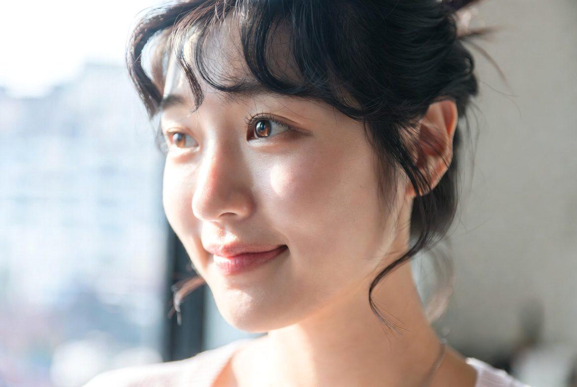午後の日差しの中で自信を持って立つ、引き締まったシルエットの女性