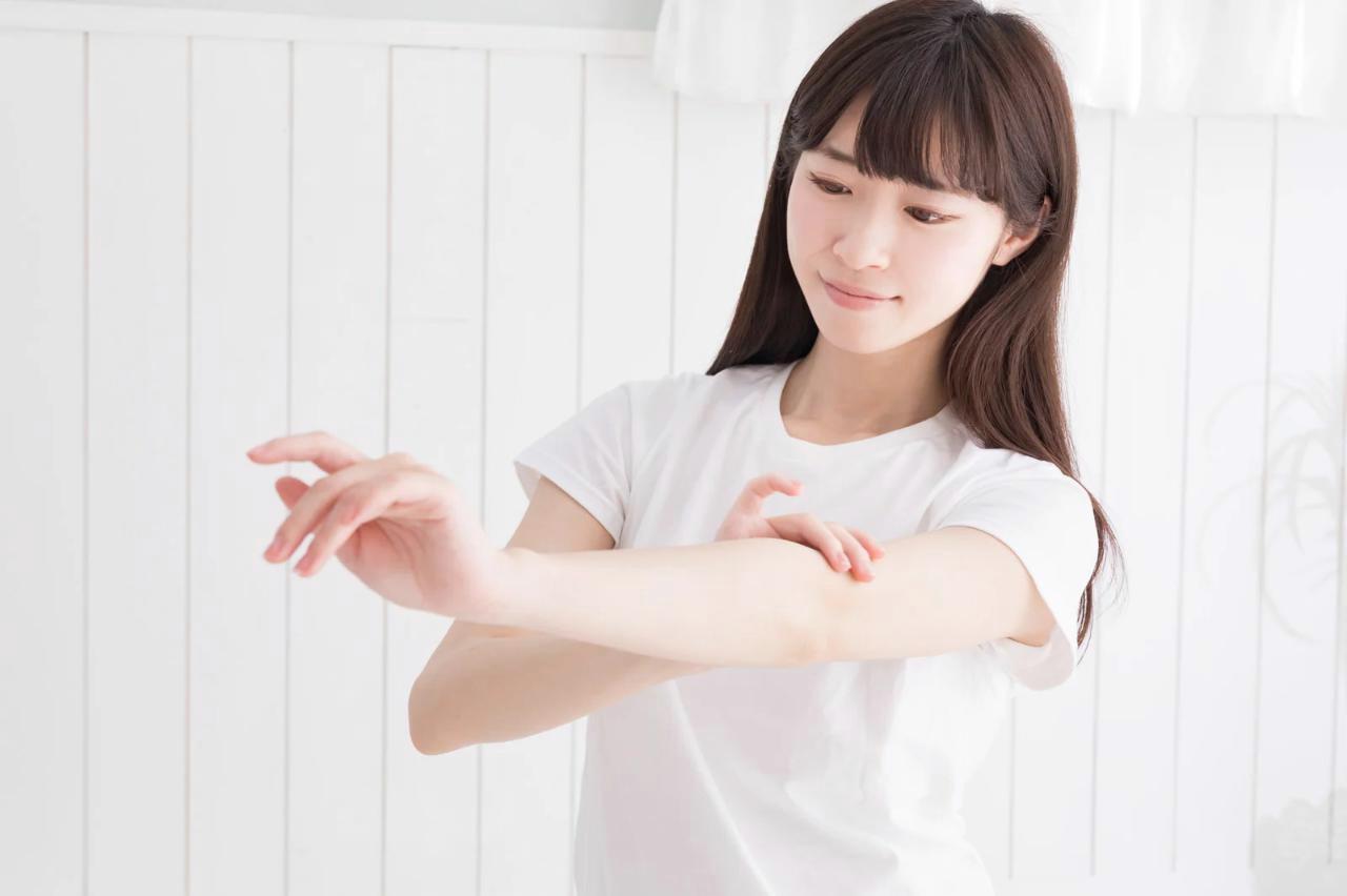 日焼け止めを手の甲に塗っている女性の手の写真